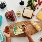 A vibrant flat lay of preparing a healthy snack with fresh ingredients like fruits, nuts, and cheese.